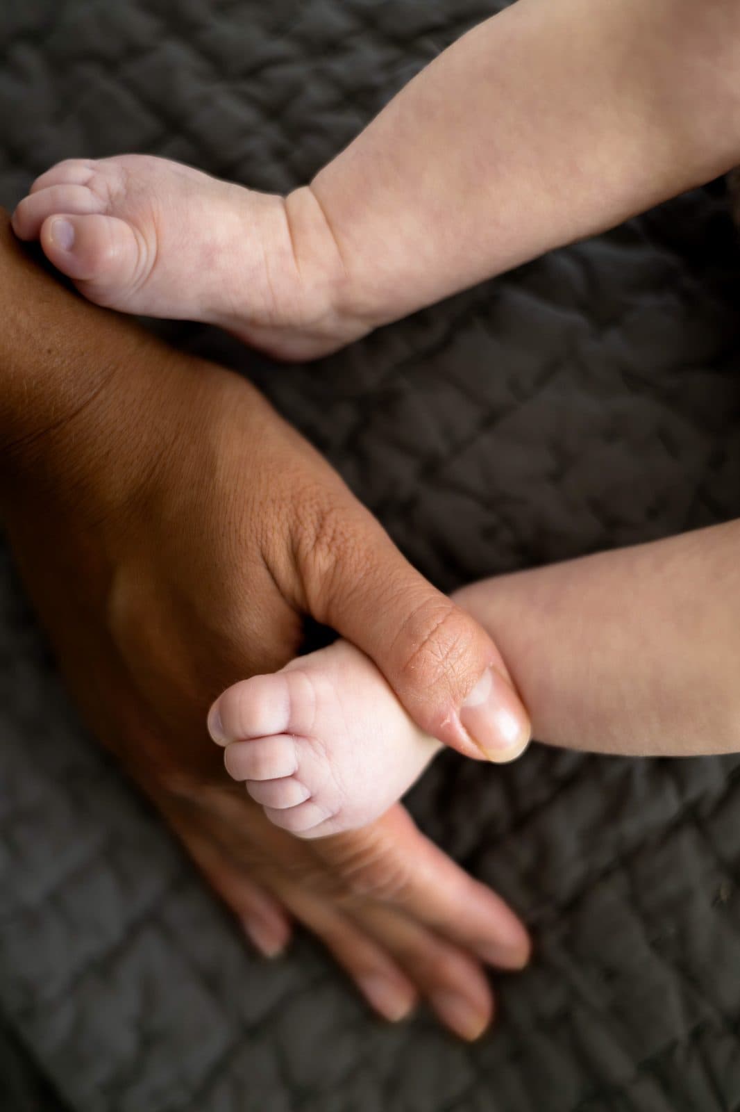 Newborn hands gripping a finger
