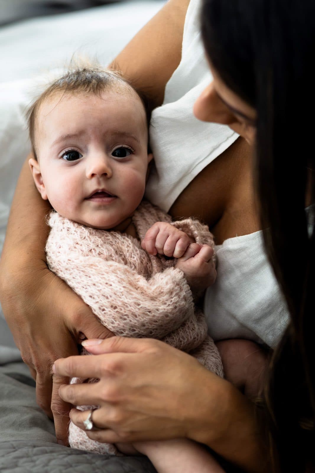 Mother holding swaddled newborn